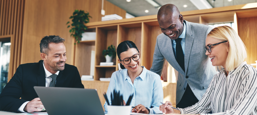 A man and woman working together at an office desk.