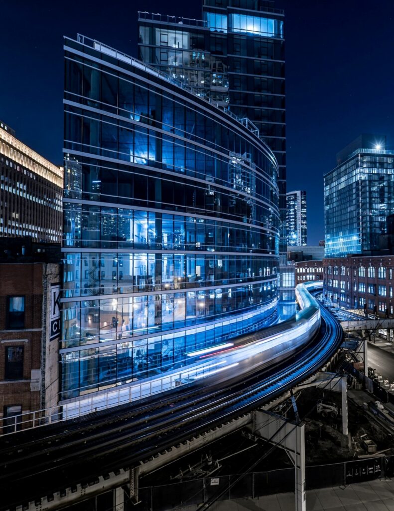 A city street with buildings lit up at night.